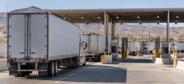 Trucks queued at a border crossing in a desert landscape