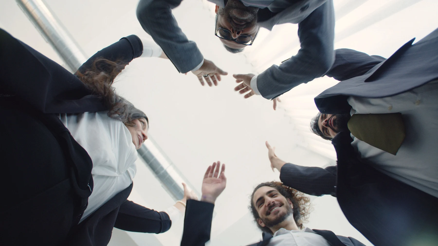 A group of coworkers joining hands in a team gesture